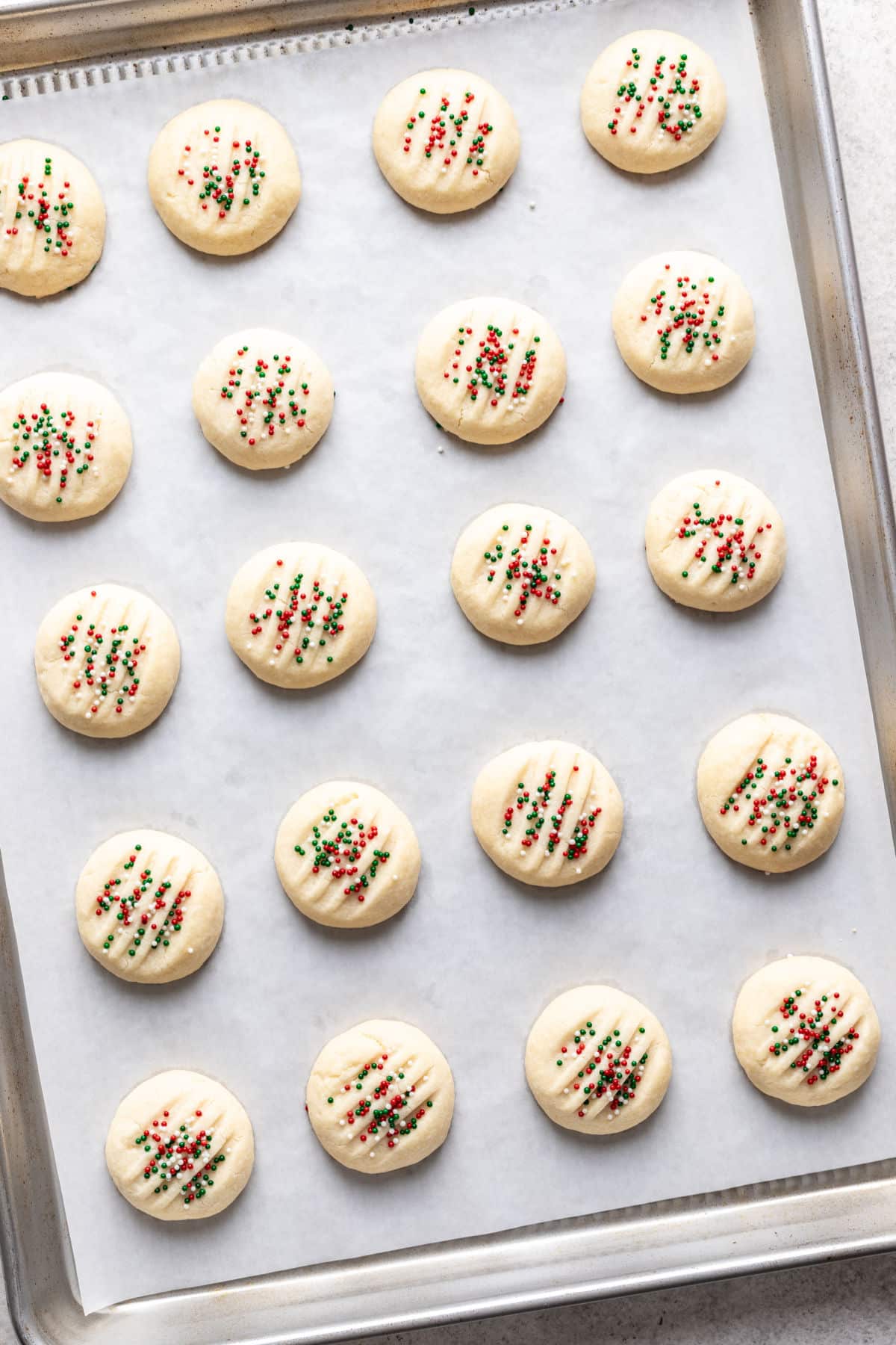 Baked whipped shortbread cookies on a baking sheet.