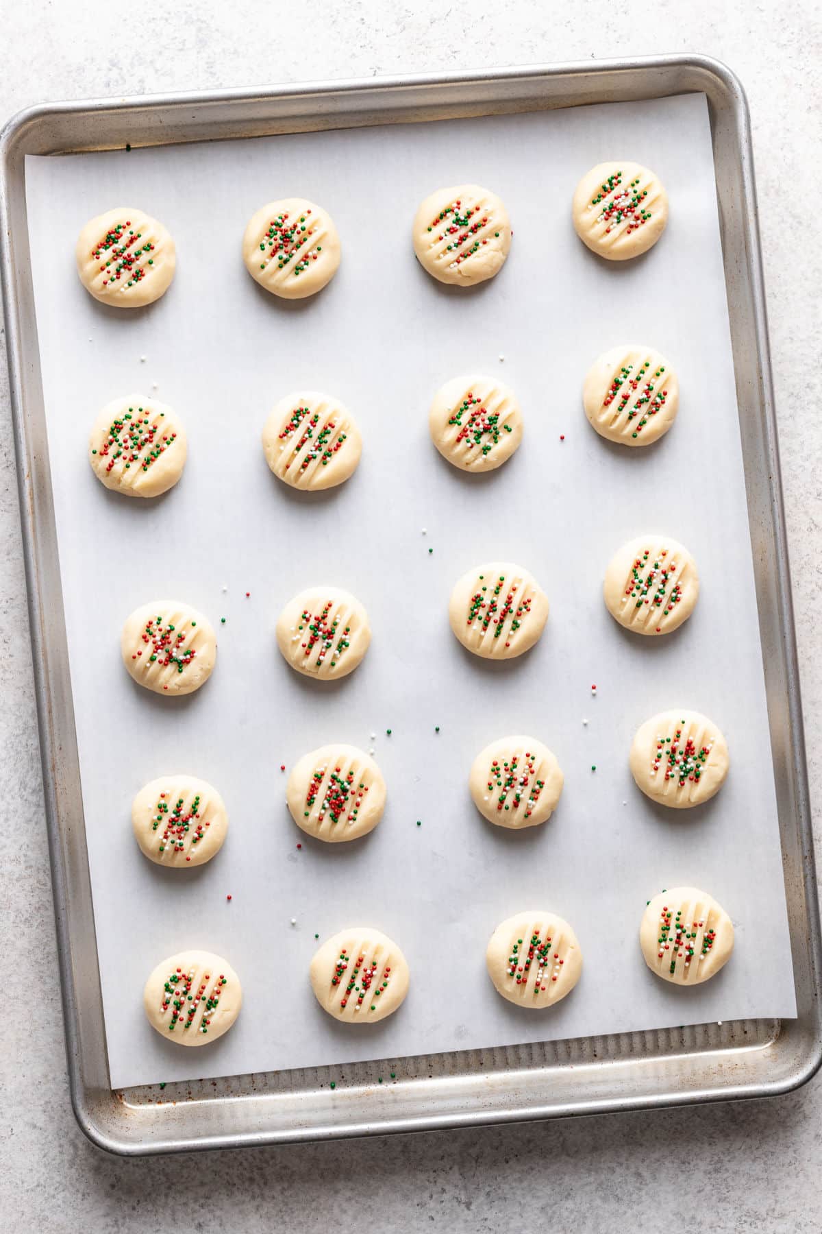 Unbaked whipped shortbread cookies on a baking sheet.