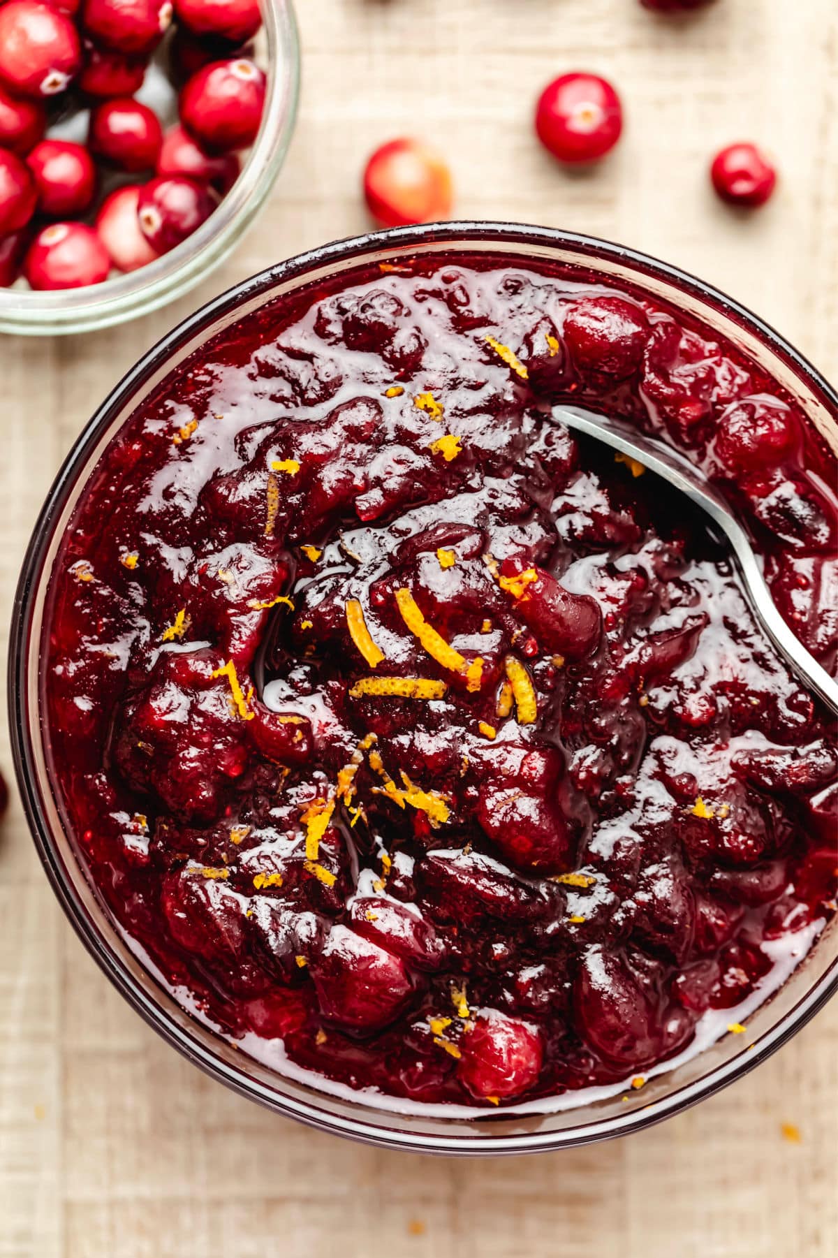 A dish of maple cranberry sauce topped with fresh orange zest.