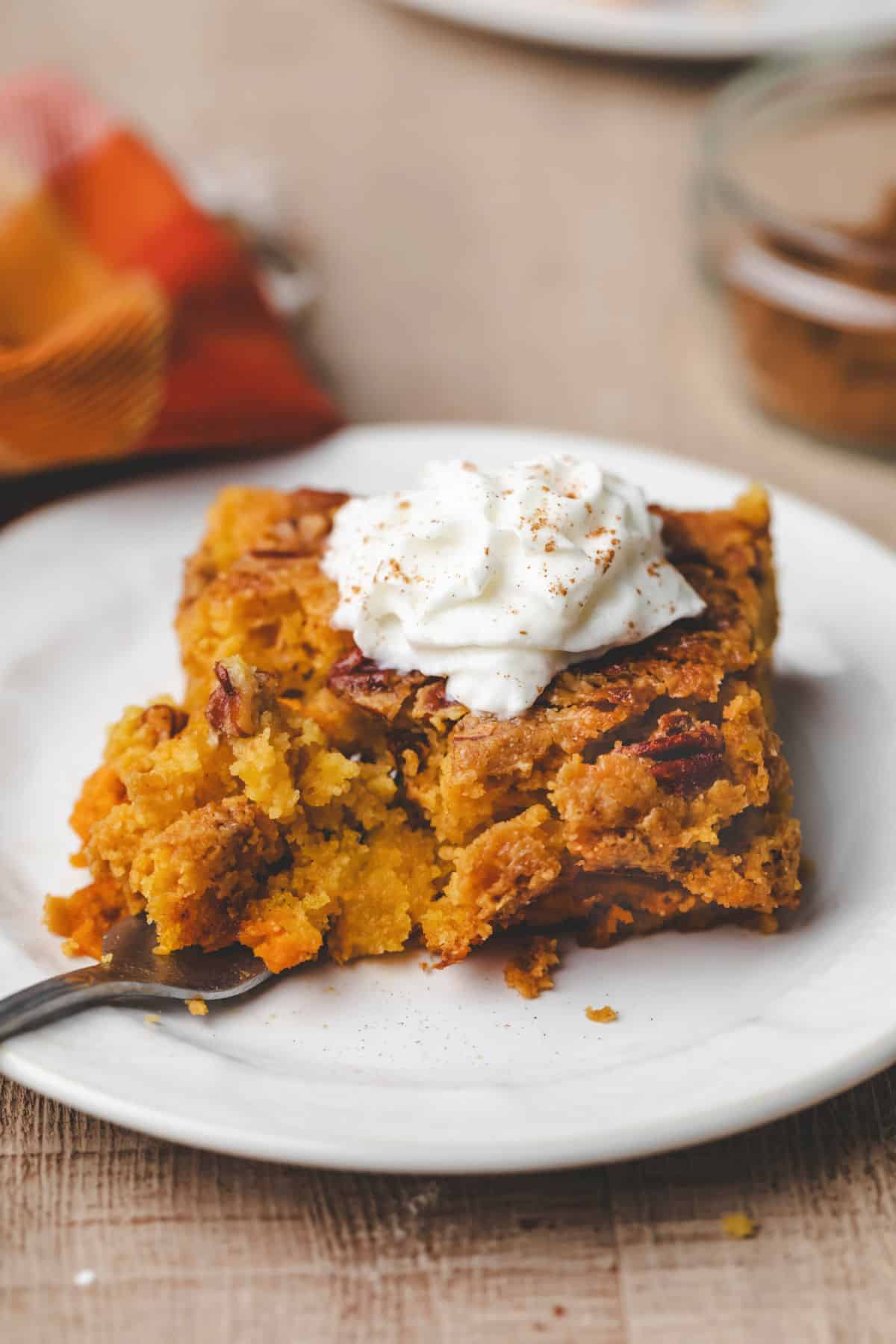 Pumpkin Pie Cake Recipe A fork taking a bite of pumpkin pie cake.