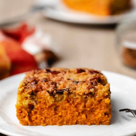A slice of pumpkin pie cake on a white plate.