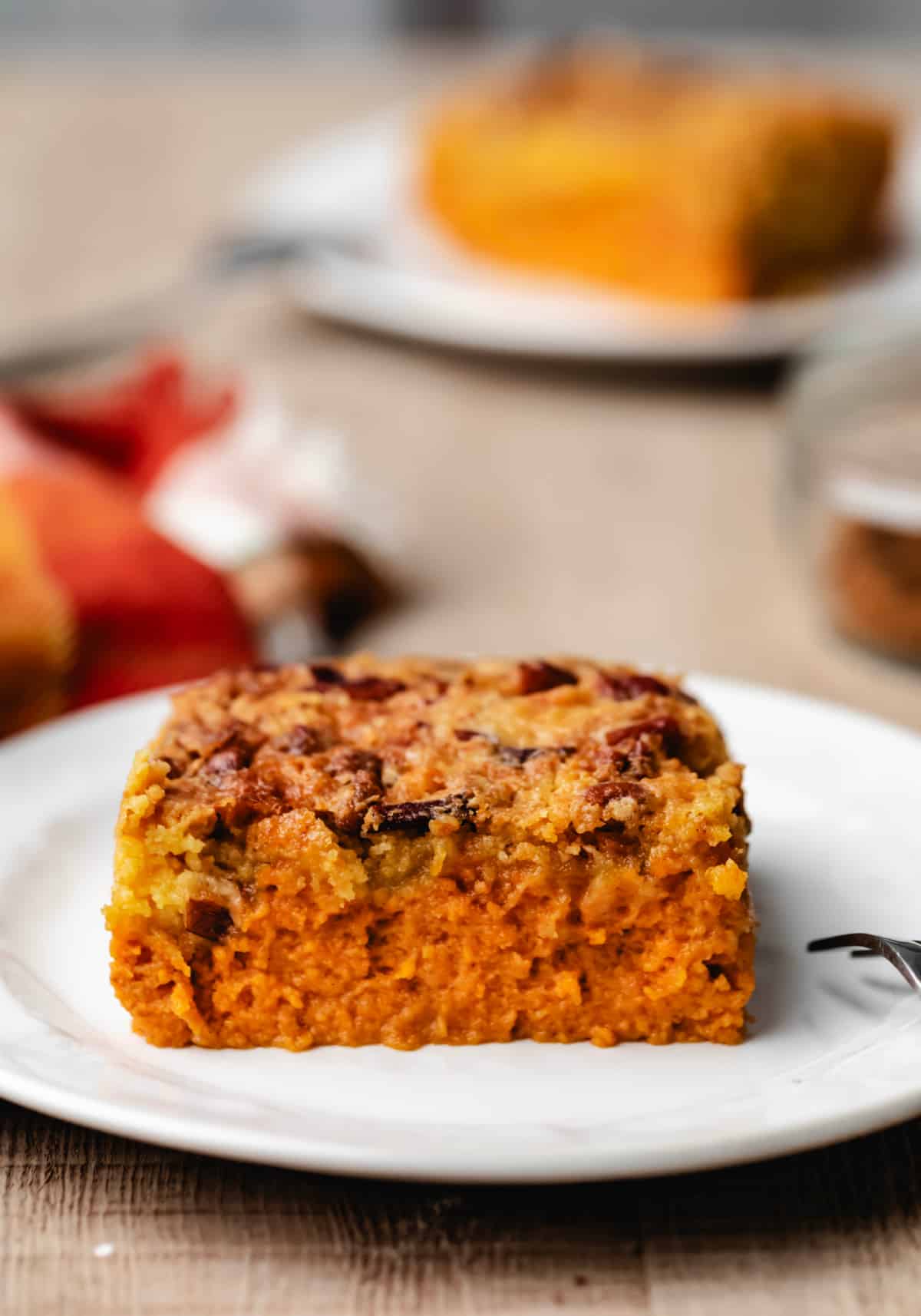 A slice of pumpkin pie cake on a white plate.