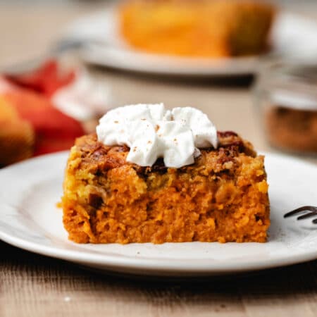 A slice of pumpkin pie cake topped with whipped cream.