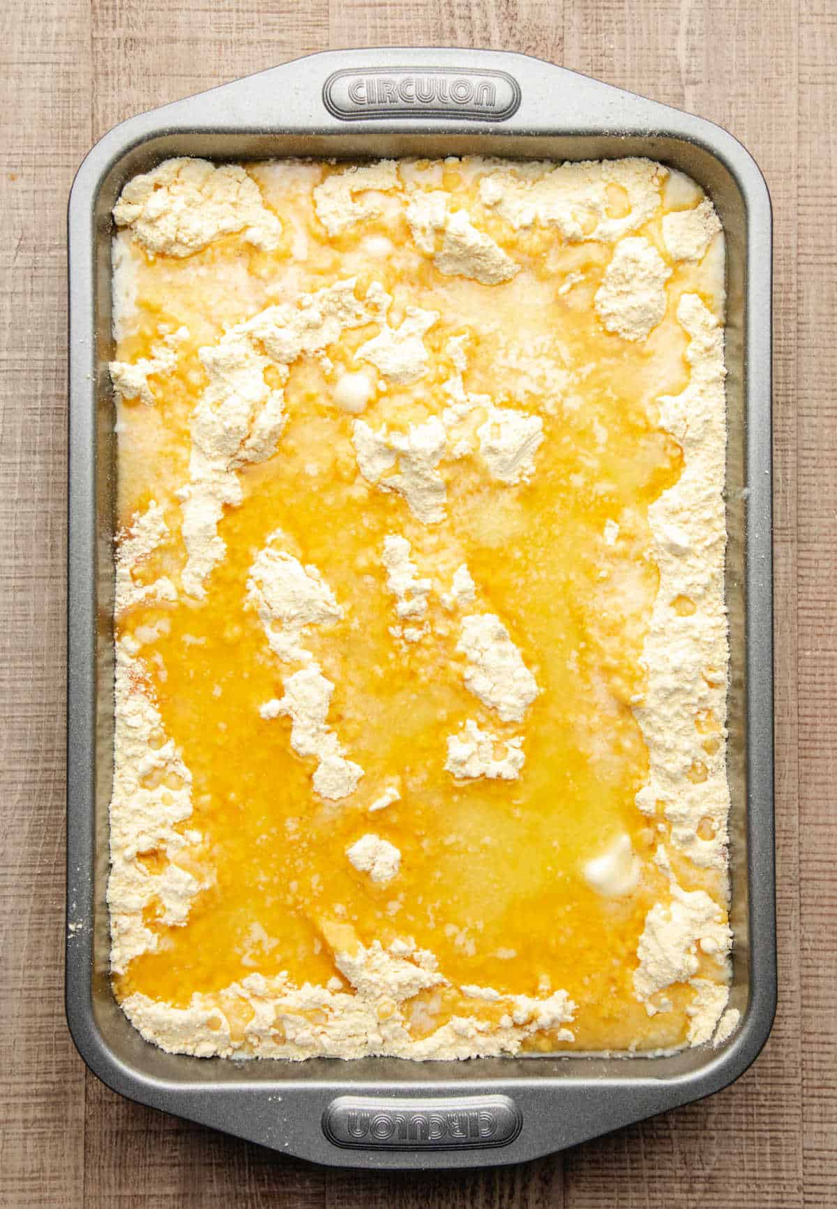 Melted butter poured over cake mix in a baking pan.
