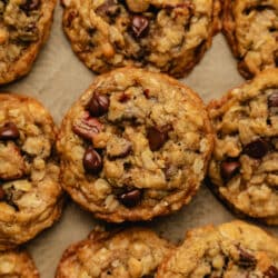 Oatmeal chocolate chip cookies on a sheet of brown parchment paper.