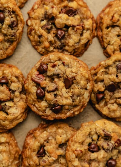 Oatmeal chocolate chip cookies on a sheet of brown parchment paper.
