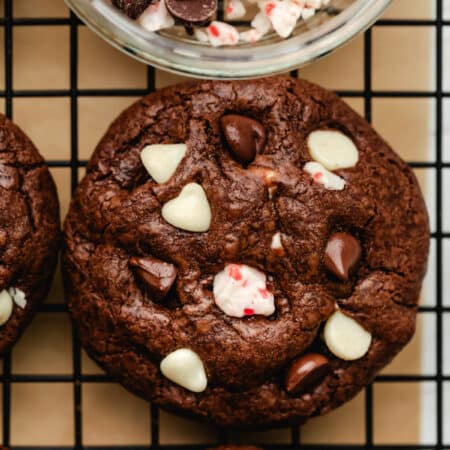 A row of peppermint bark cookies next to a dish of peppermint bark pieces.