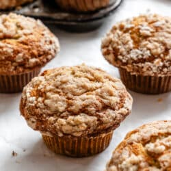 Banana crumb muffins next to a vintage muffin pan.