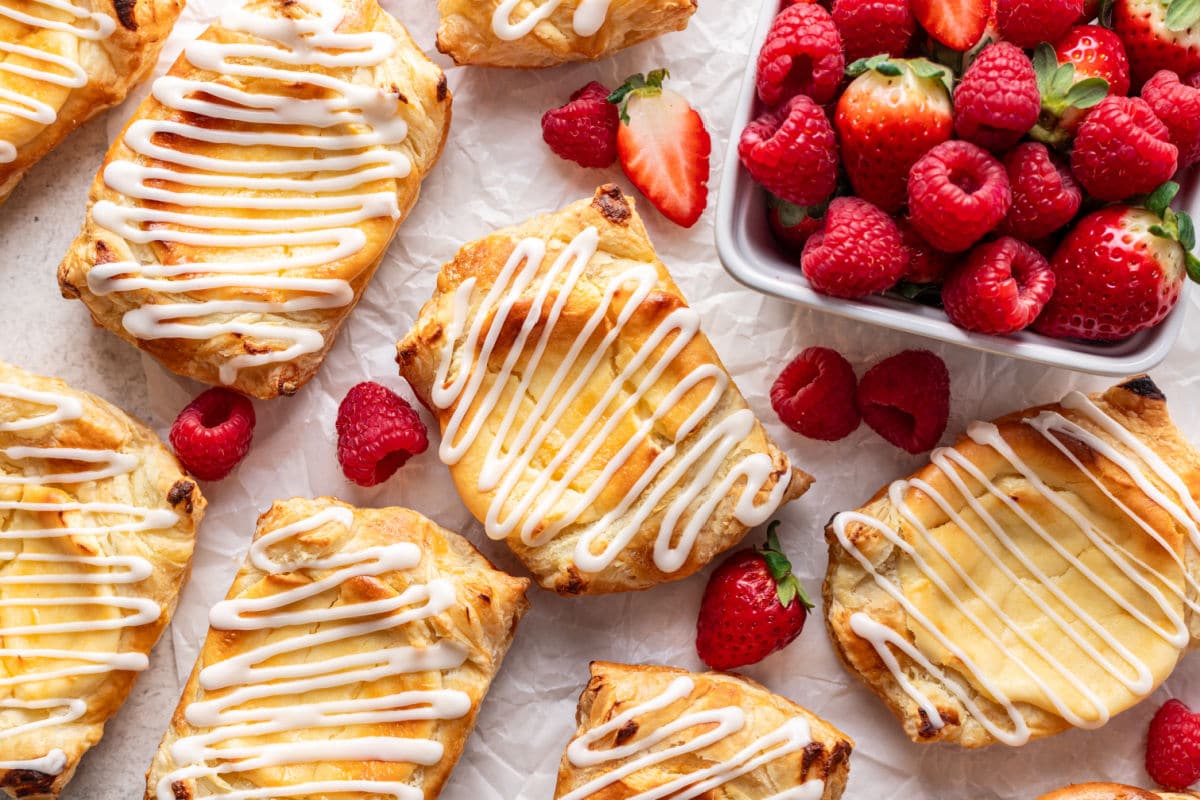 Cream cheese danishes next to a dish of fresh berries.