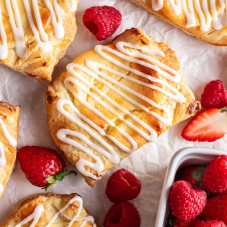 Homemade cheese Danishes surrounded by fresh berries.