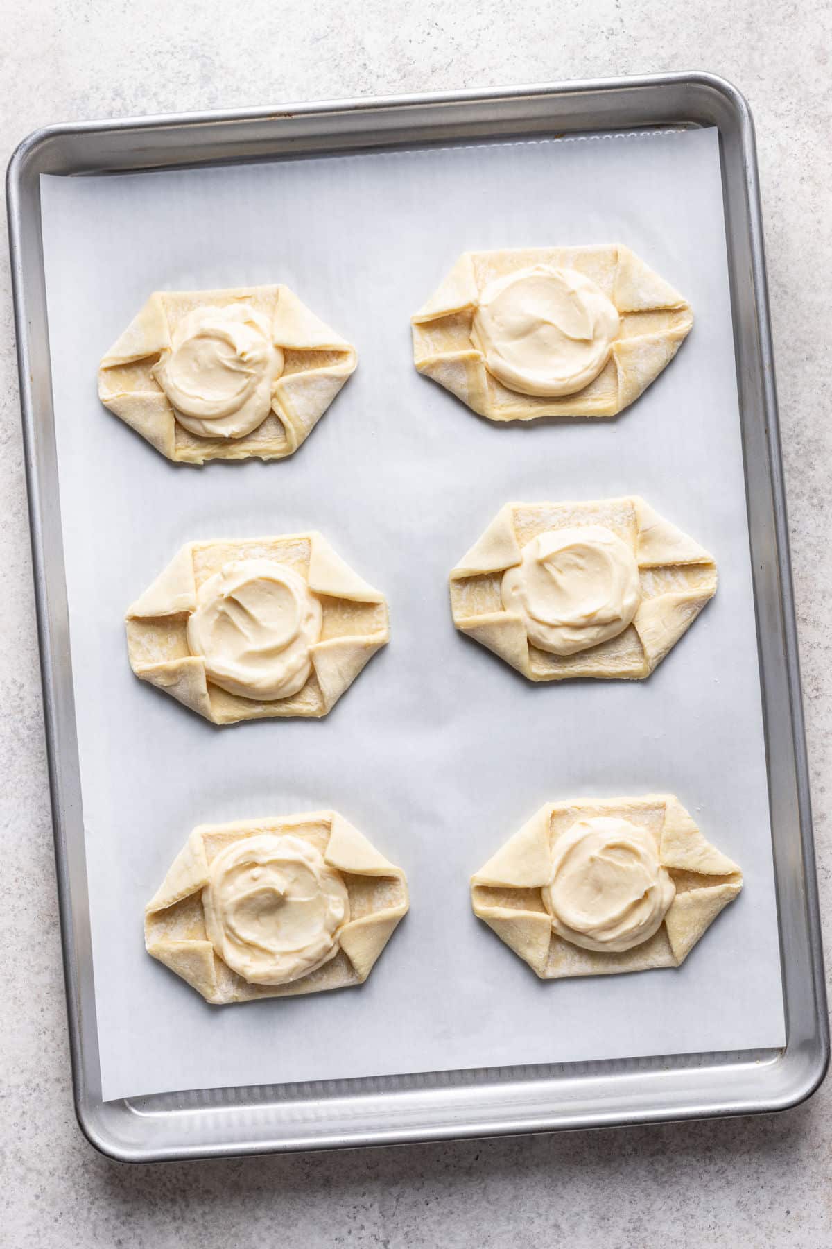 Cream cheese filling in middle of a piece of puff pastry dough.