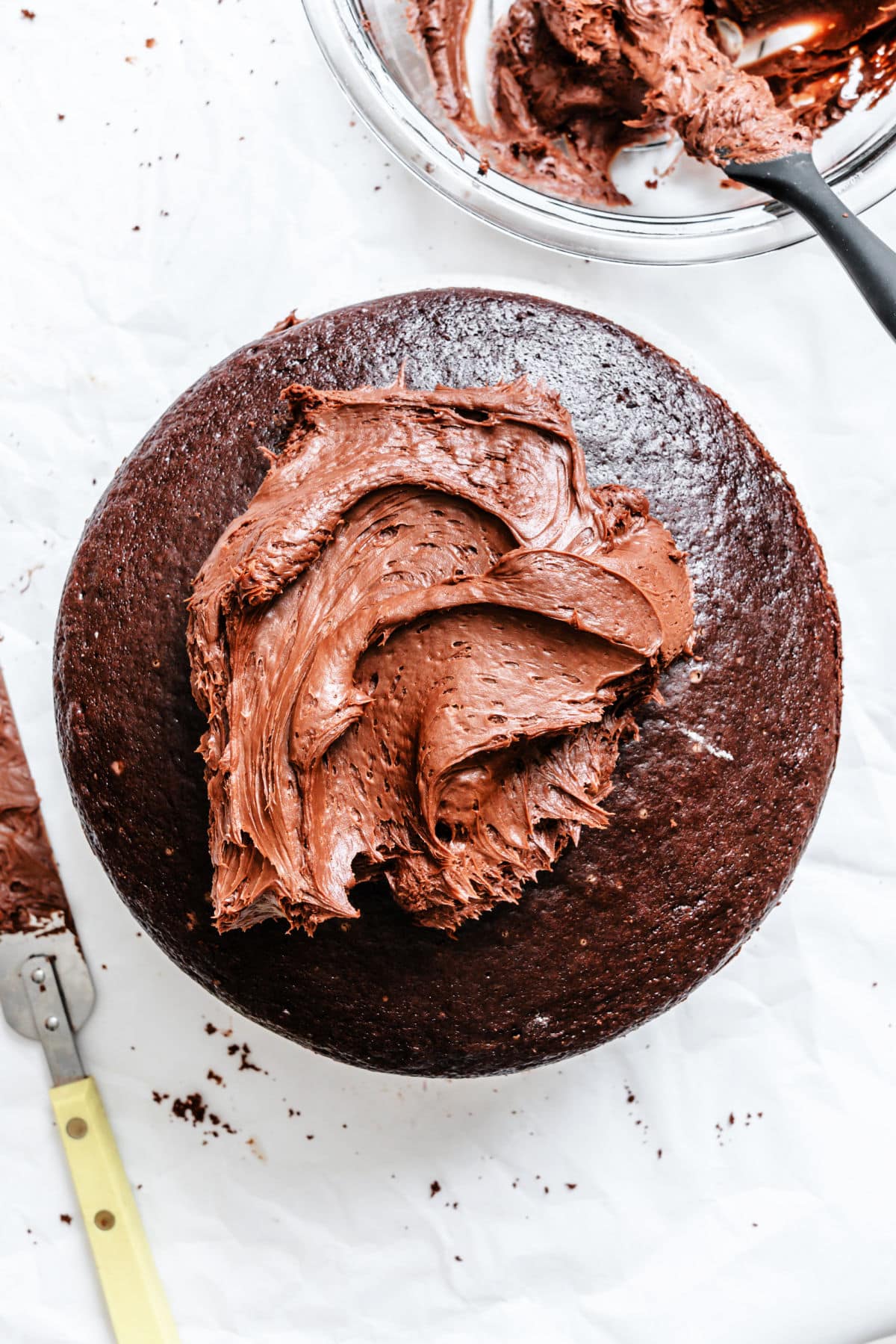 Chocolate buttercream frosting spread over a layer of chocolate fudge cake.