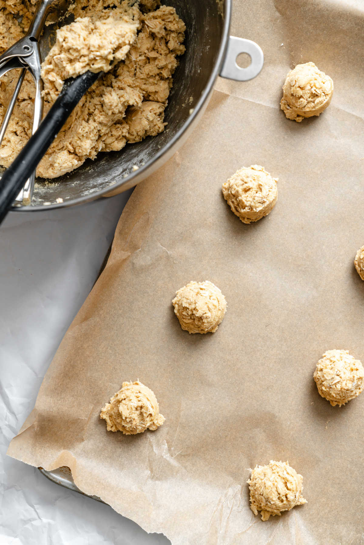 Oatmeal cookie dough on a sheet of brown parchment paper.