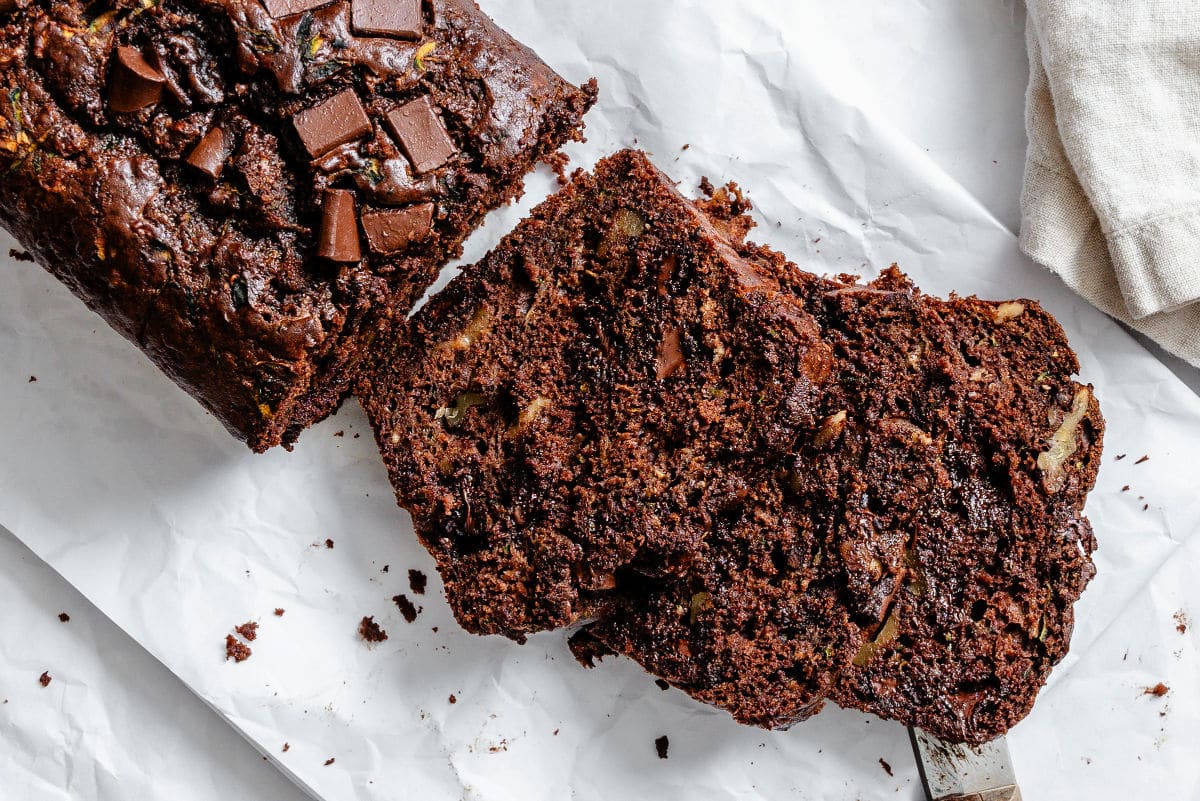 Slices of chocolate zucchini bread next to the loaf.
