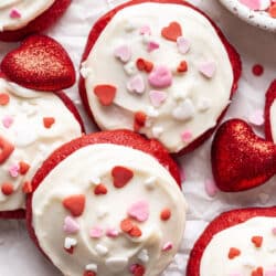 Overlapping Red Velvet Cupcake cookies topped with Valentine's Day sprinkles.