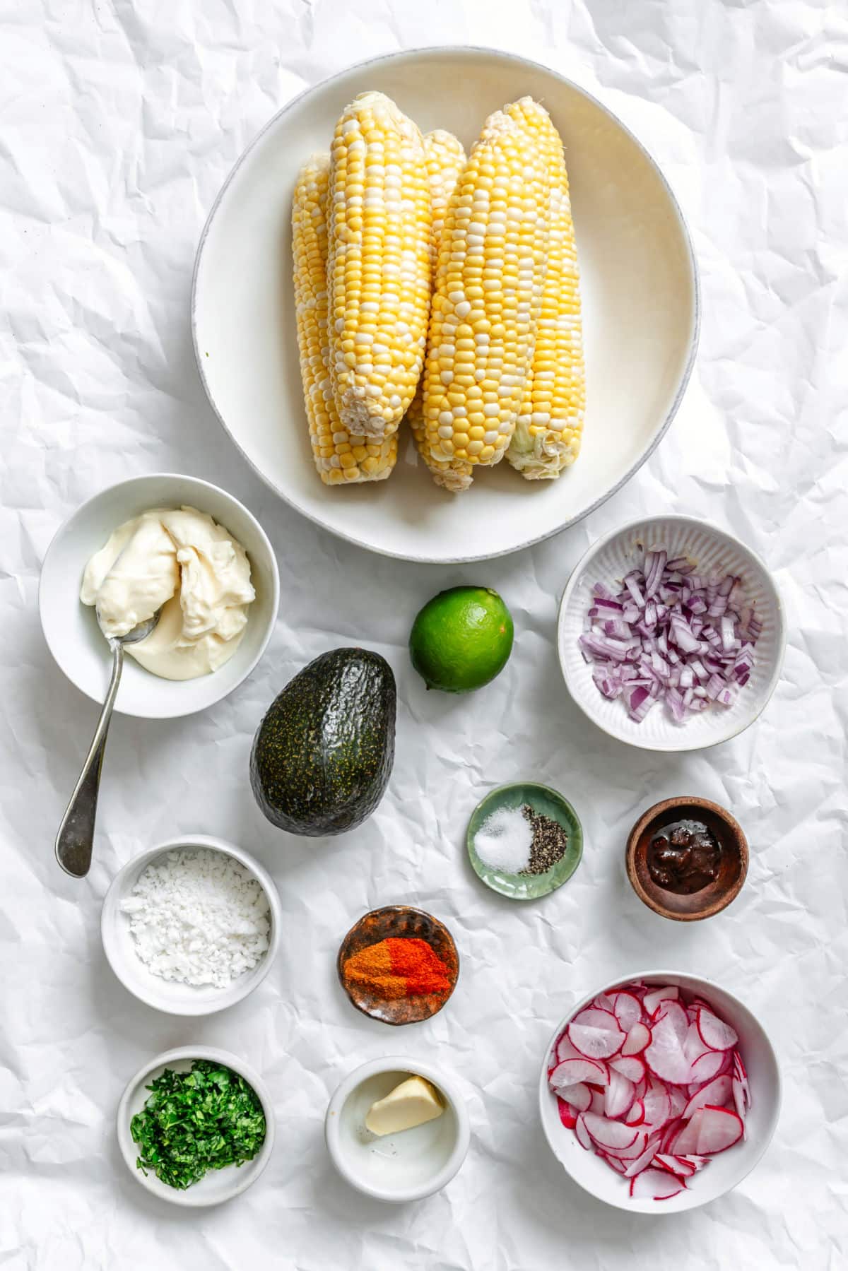 Ingredients for Mexican street corn salad in dishes.