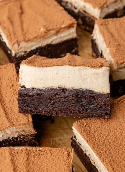 A tiramisu brownie sideways on a stack of brownies.