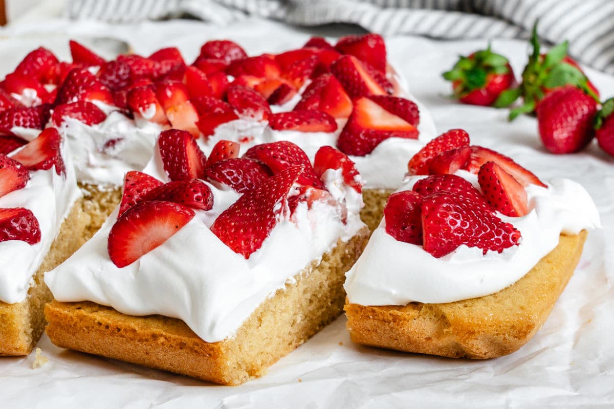 Two cut pieces of strawberry shortcake bars next to the bars.