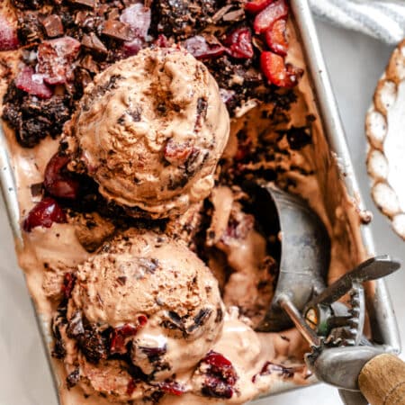An old fashioned ice cream scoop scooping up black forest ice cream.