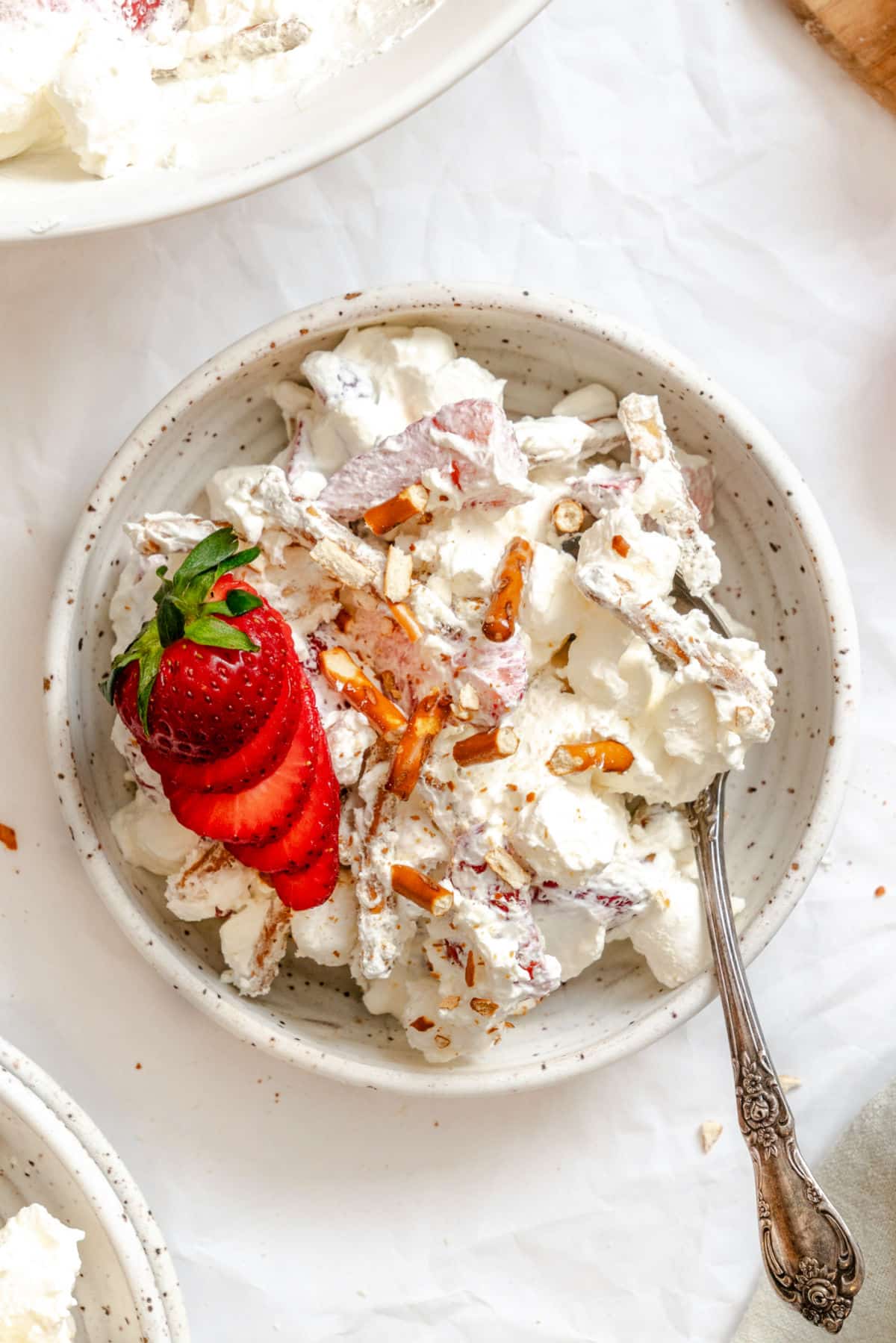 A dish of strawberry pretzel fluff topped with sliced fresh strawberries.