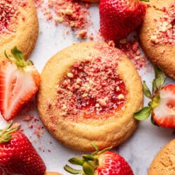 Strawberry shortcake cookies surrounded by fresh strawberries.