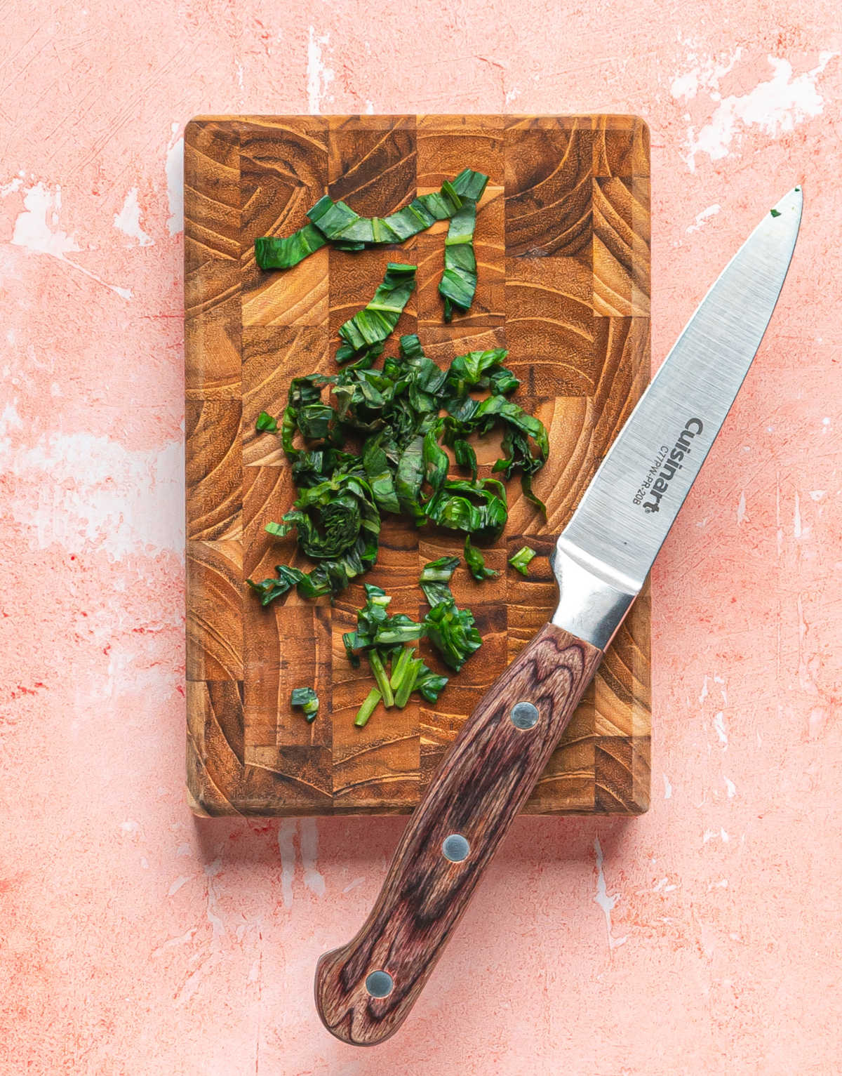 Basil cut in chiffonade on a wooden cutting board.