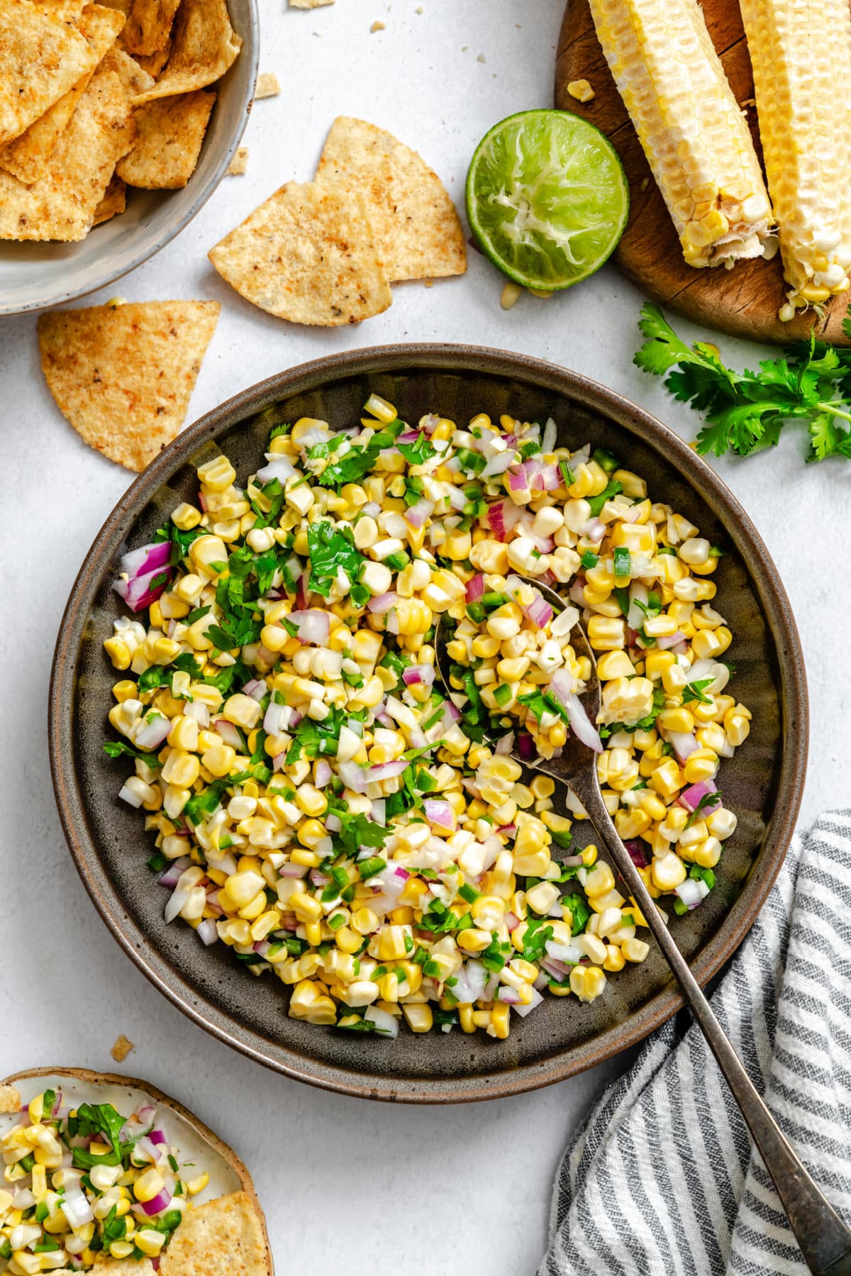 Fresh Corn Salsa A dish of corn salsa next to tortilla chips and limes.