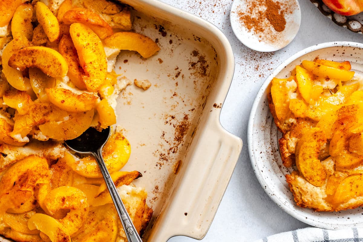 A dish of upside down peach cobbler next to a plate of cobbler.