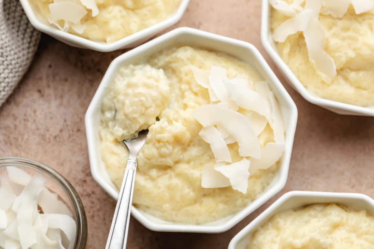 Ramequins de pudding de riz au coco garnis de copeaux de noix de coco.
