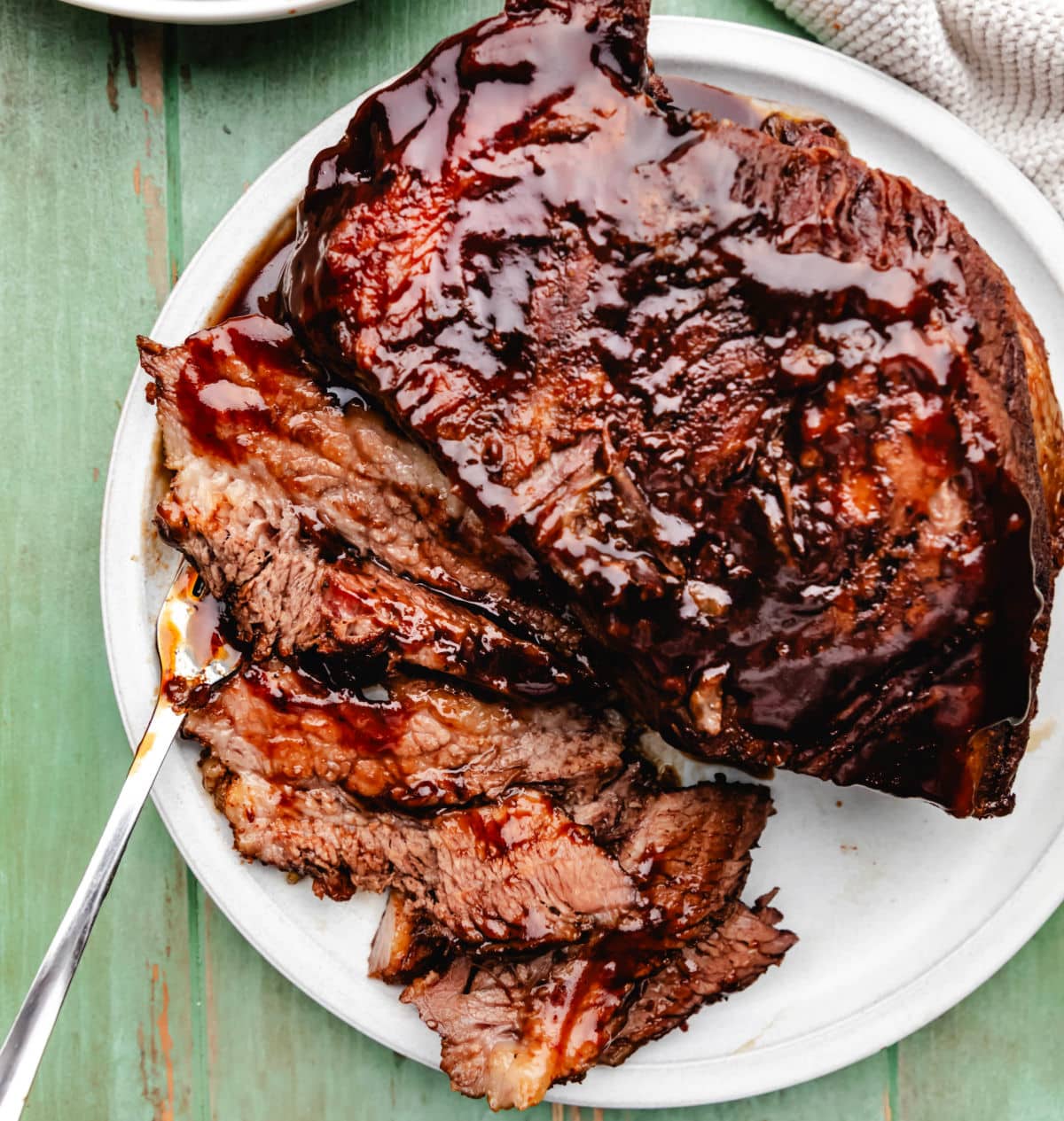Discover brisket and a piece of beef brisket on a white plate.
