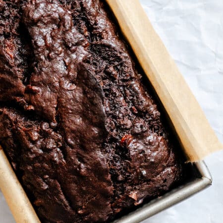 A loaf of baked chocolate banana bread in a pan.