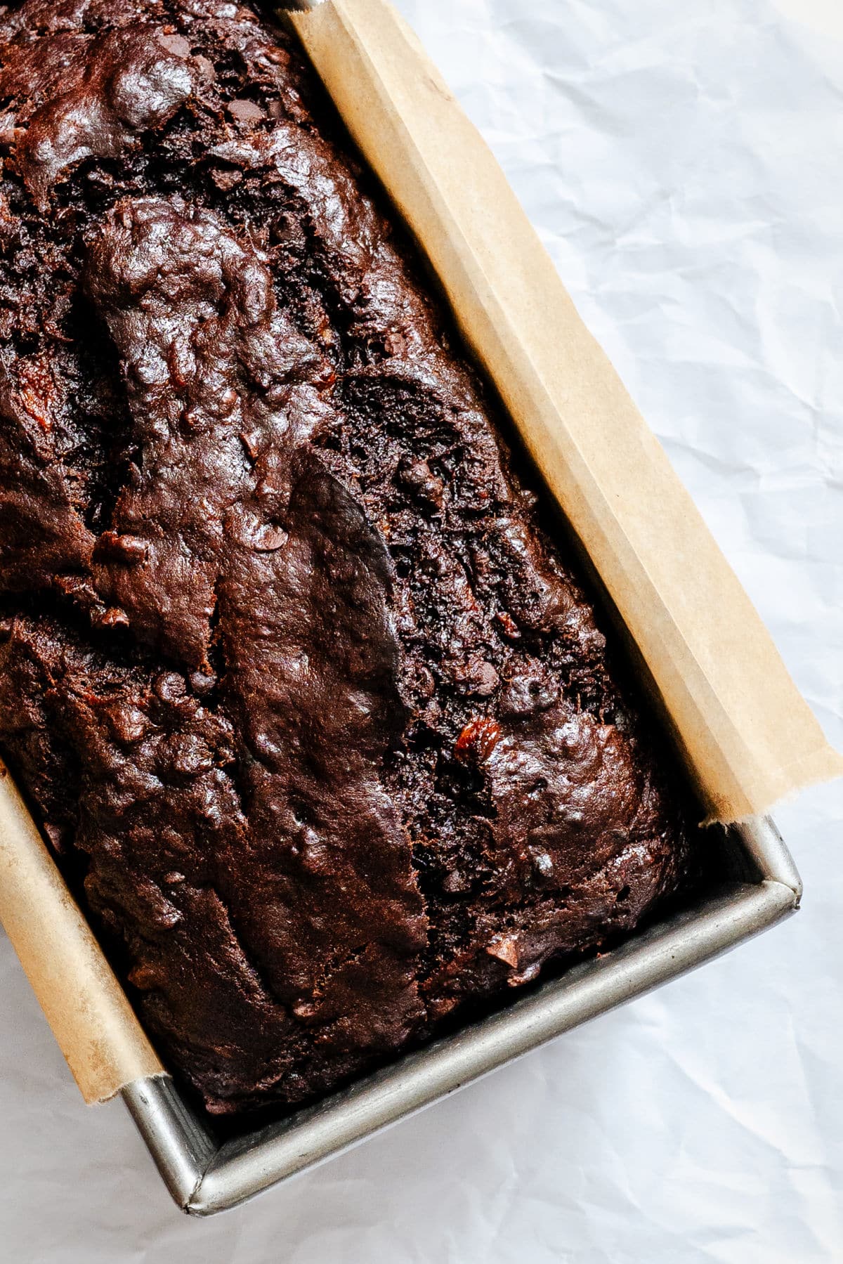 A loaf of baked chocolate banana bread in a pan.