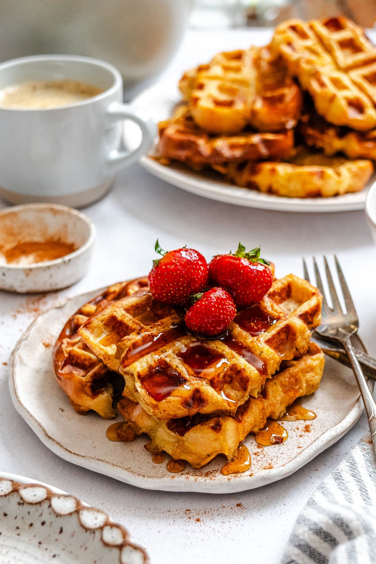 Une assiette de gaufres de pain perdu garnies de fraises fraîches.