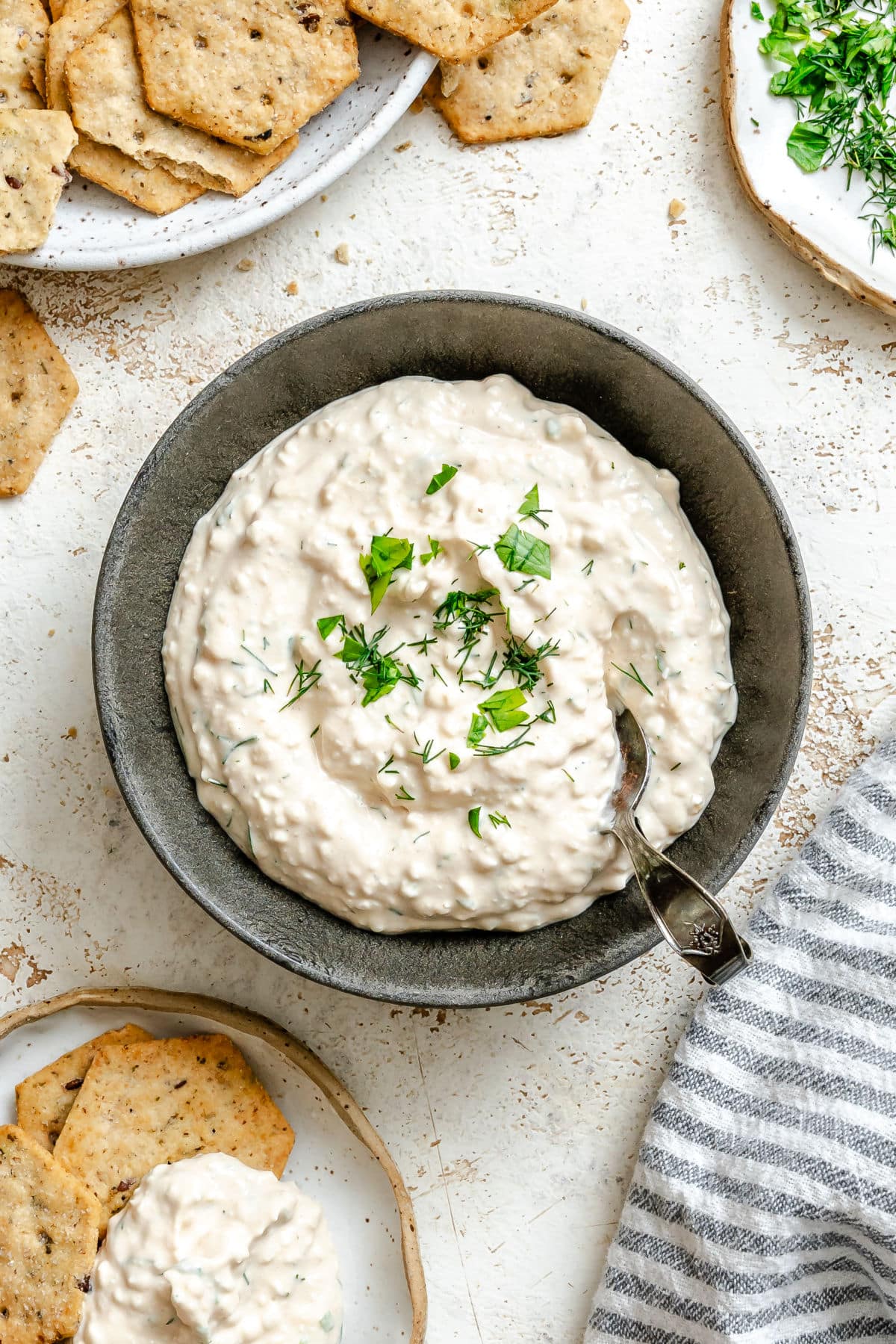 Un plat de dip aux herbes avec du fromage cottage garni d'herbes fraîches.