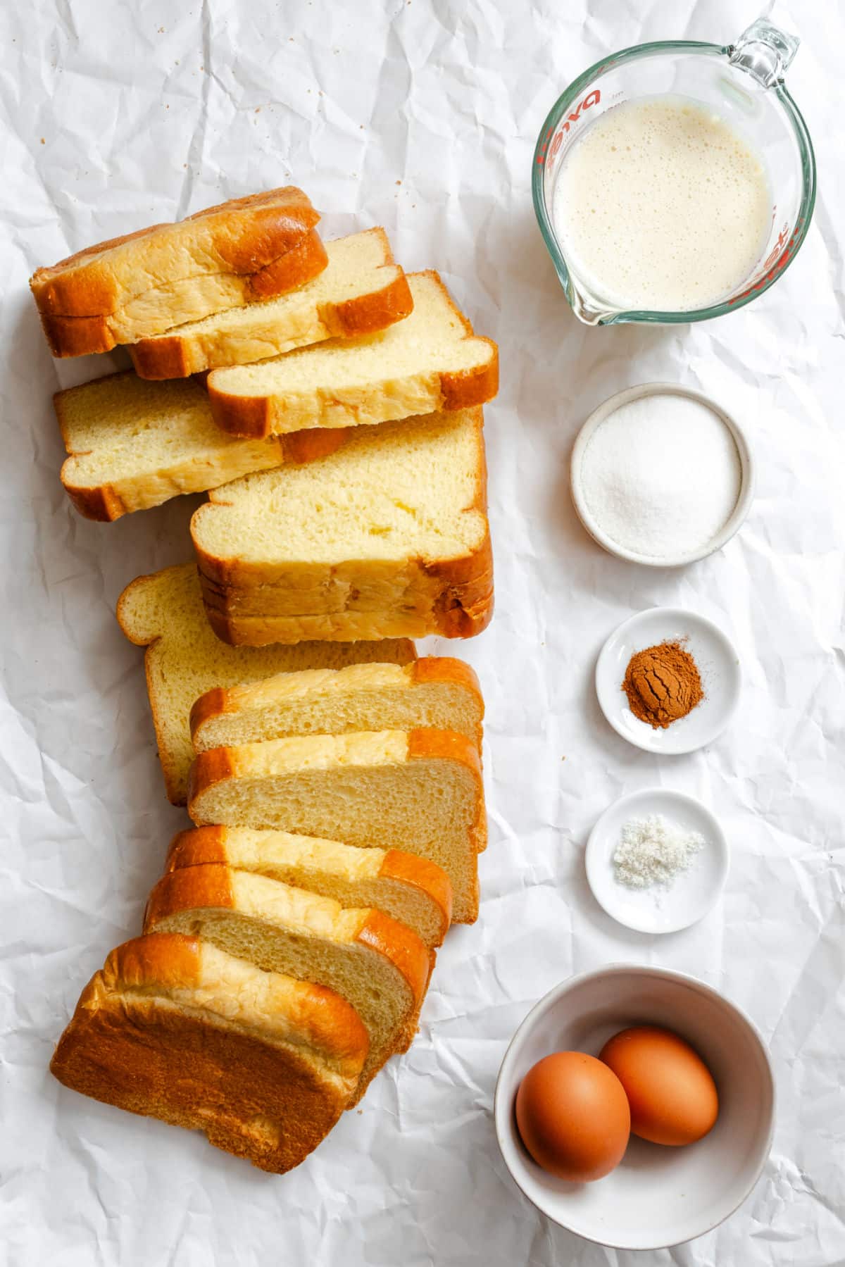 Ingredients for homemade French toast sticks in dishes. 