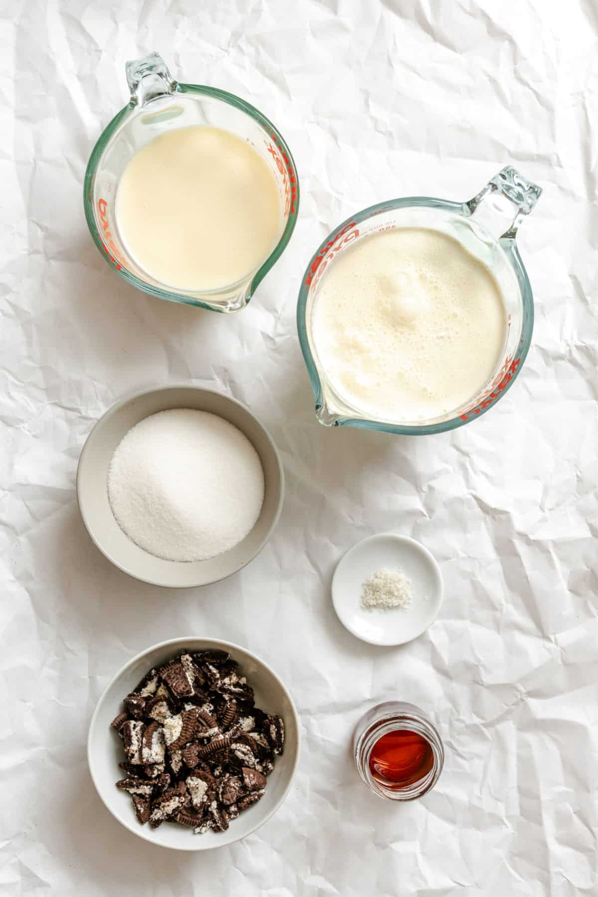 Ingredients for no churn cookies and cream ice cream in dishes.
