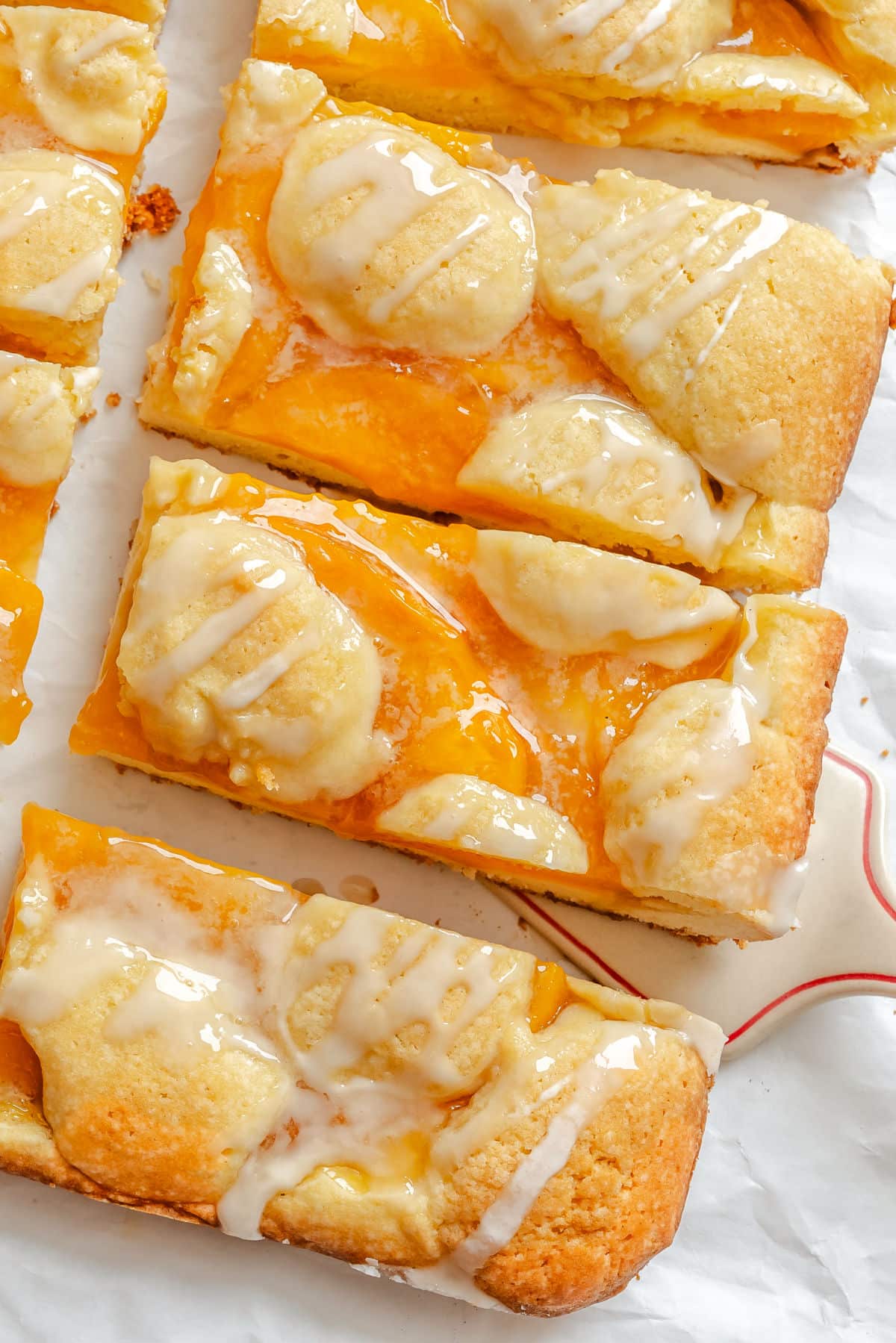 A server removing a peach pie bar from a row of bars.