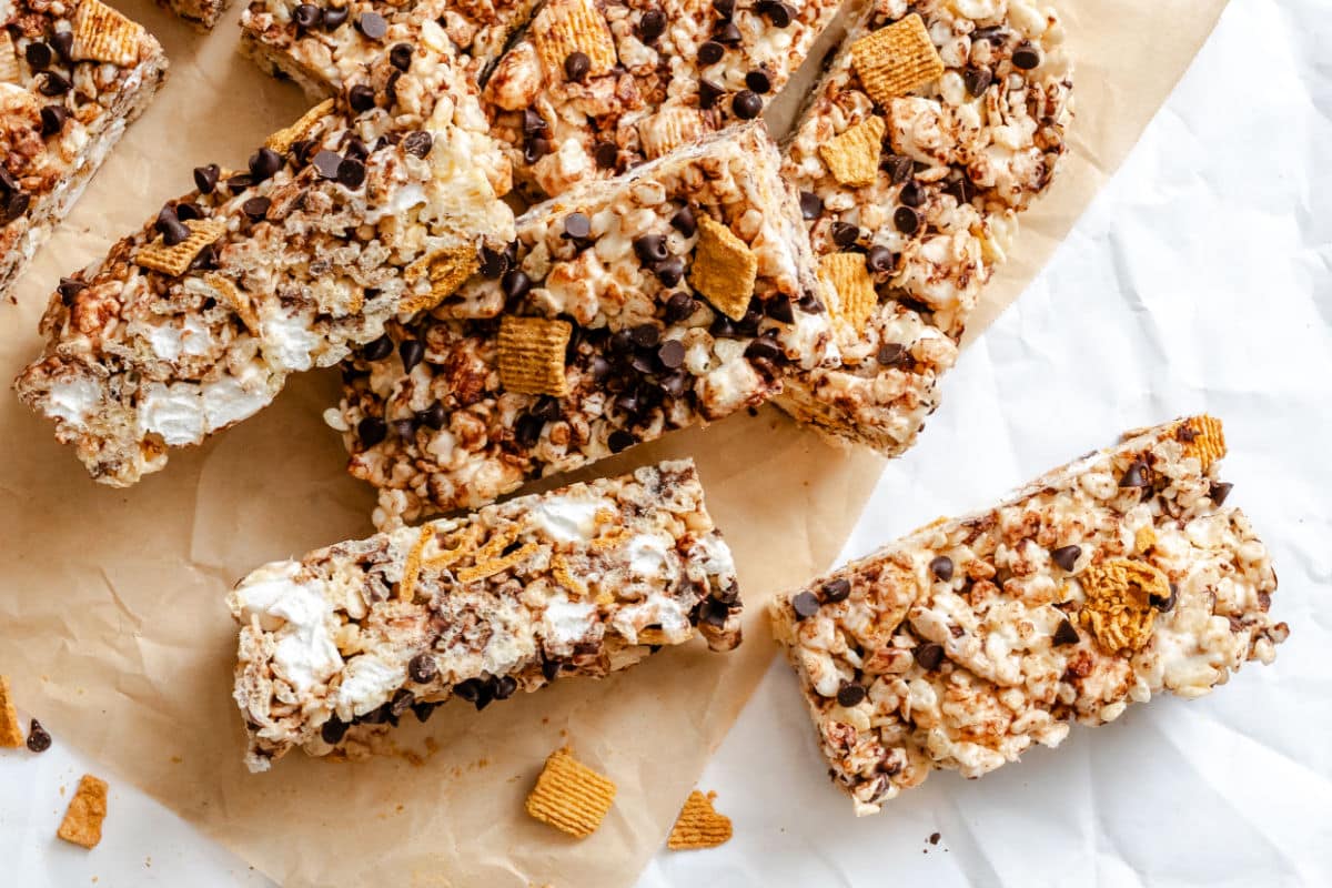 Overlapping cut s'mores Rice Krispies treats on a piece of brown parchment paper.