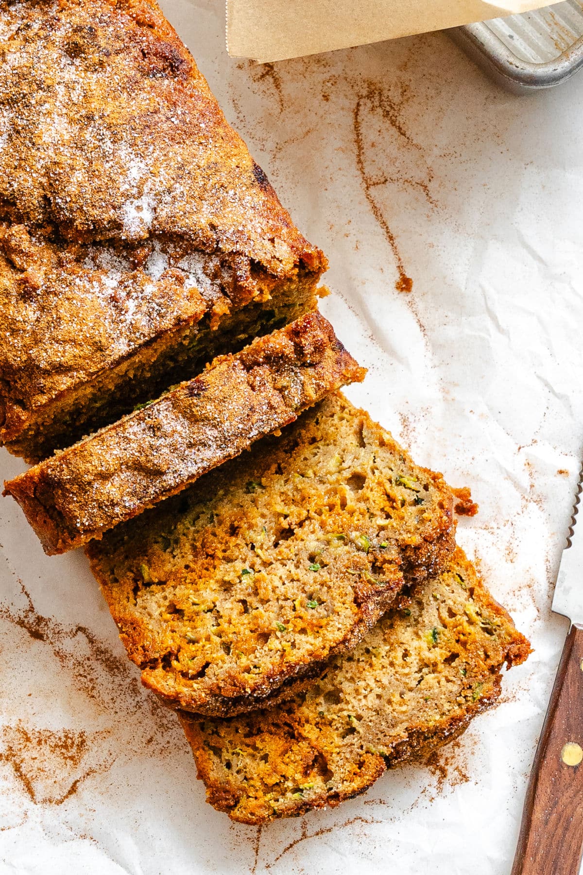 Cinnamon Chip Whole Wheat Zucchini Bread Three slices of whole wheat zucchini bread next to the rest of the loaf.