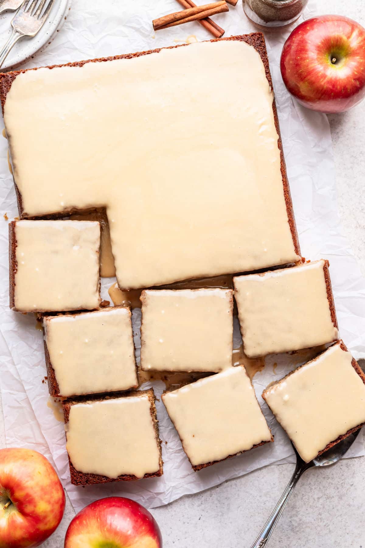 A caramel apple sheet cake with slices cut next to it.