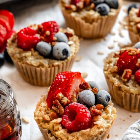 Rows of freezer oatmeal cups on white parchment paper.