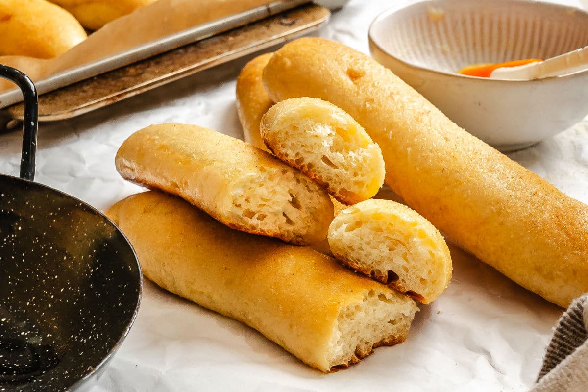 Garlic breadsticks in a stack with two in half. 
