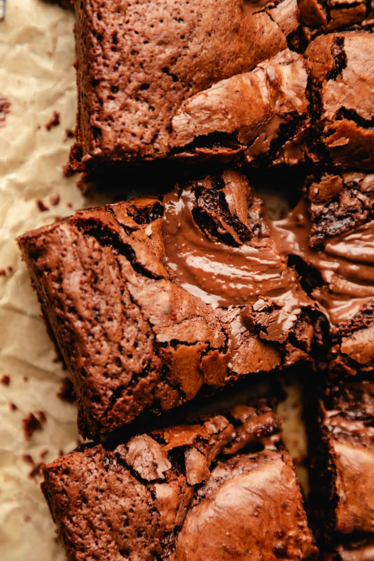 Cut Nutella brownies at an angle on brown parchment paper. 