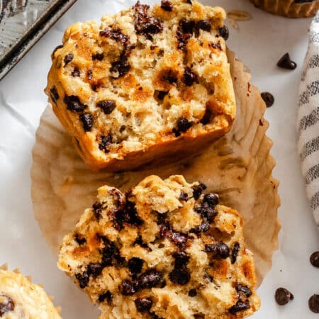 An oatmeal chocolate chip muffin cut in half in a muffin liner.