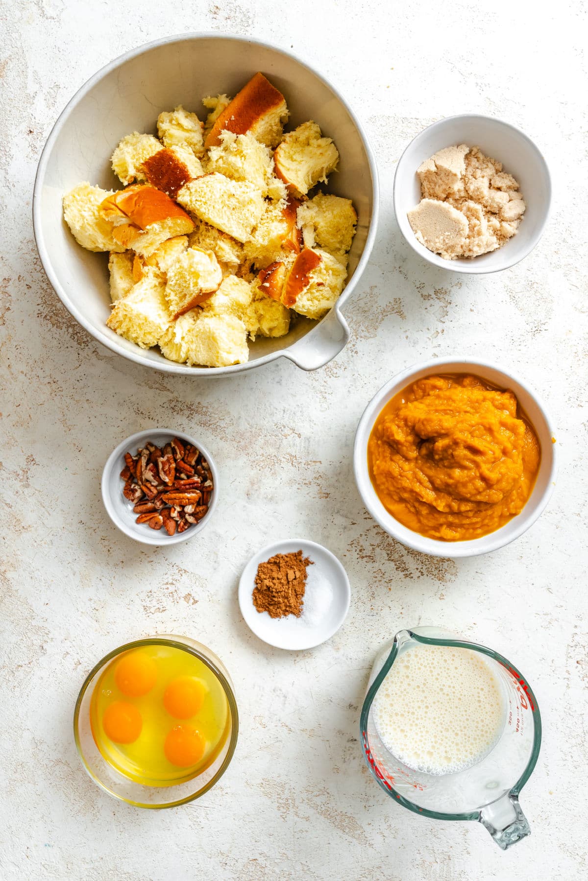Ingredients for pumpkin bread pudding in dishes.