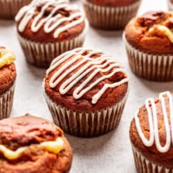 Pumpkin cream cheese muffins drizzled with cream cheese drizzle.