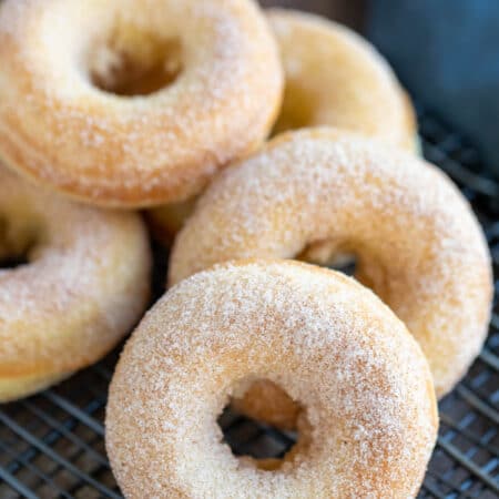 Baked cinnamon sugar donuts on a wire cooling rack.