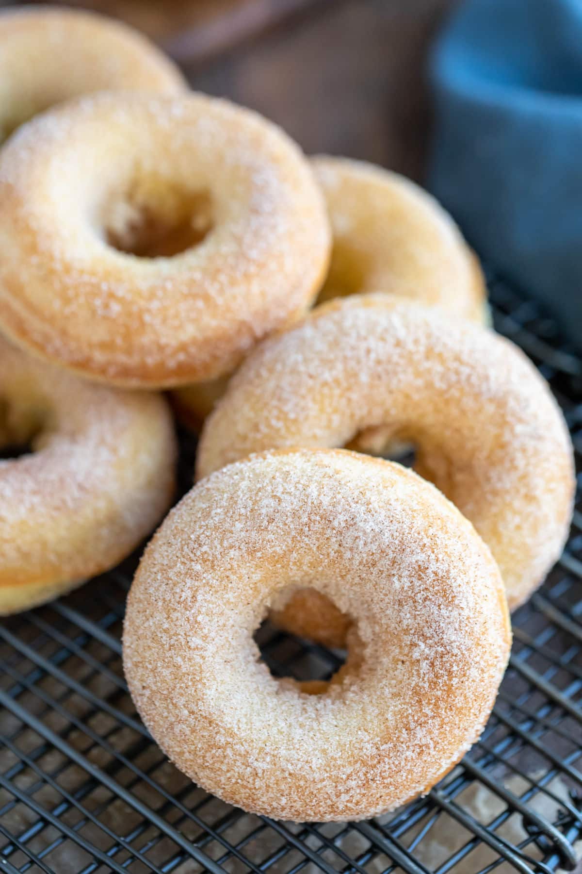 Baked cinnamon sugar donuts on a wire cooling rack.
