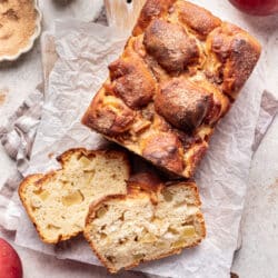 Two slices of apple cinnamon bread leaning next to the loaf.