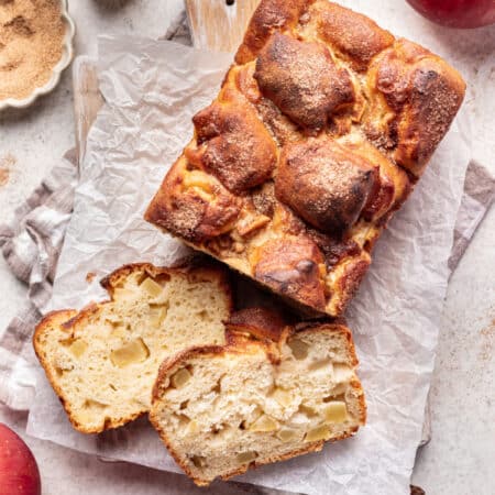 Two slices of apple cinnamon bread leaning next to the loaf.